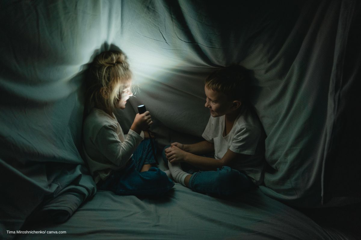 Kinder mit Taschenlampe in der Höhle